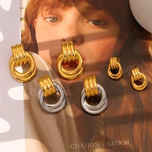 Detailed close-up of mixed-color interconnected circle stud earrings with unique light patterns