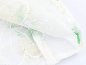 Close-up of elegant floral print on white cotton-linen fabric with seam detail