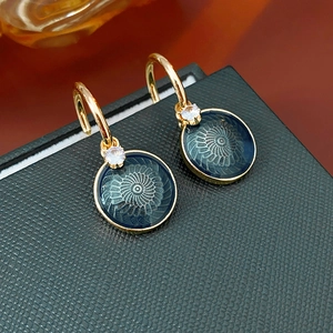 Detailed view of vintage flower stud earrings with dark blue enamel and gold trim