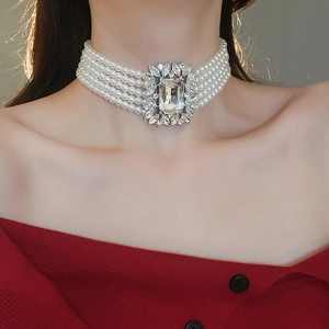 Close-up of layered pearl necklace with square zircon centerpiece worn by a model