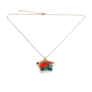 Detailed macro view of star pendant with colorful glass inlay and golden chain