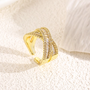 Close-up of gold plated crisscross ring with zircon pavé setting and adjustable open band
