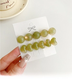 Detail of green jelly heart and round bead hair clips set on display card