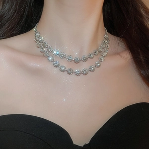 Close-up of elegant double-layer silver necklace with sparkling rhinestone spheres on neck