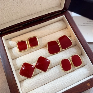 Set of four red enamel geometric earrings with gold frames in a wooden jewelry box