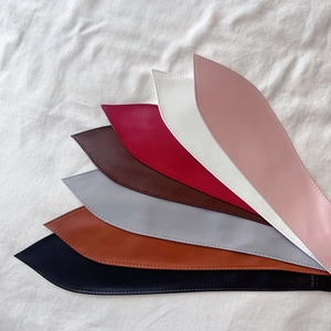 Détail de diverses ceintures en cuir PU avec coutures de précision en plusieurs couleurs
