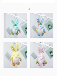 Detalle de cuatro gnomos de Pascua colgantes con orejas de conejo y adornos de colores