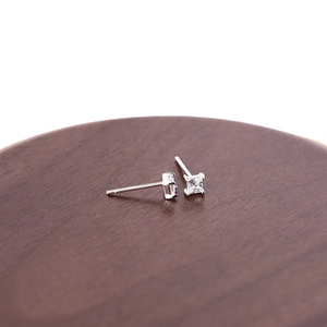 Minimalist silver square zircon stud earrings for women on a dark wooden base