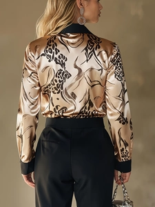 Detail of champagne gold satin shirt with black artistic print showing fabric texture