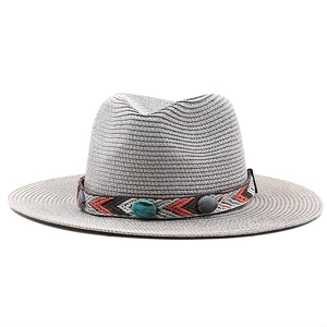 Détail d'un chapeau de paille gris avec ruban ethnique et accents de pierres turquoise