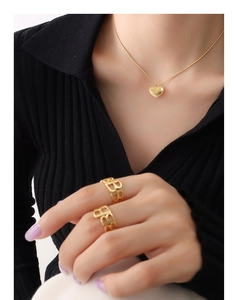 Detail view of 18K gold plated heart necklace and hollow B-letter rings on model