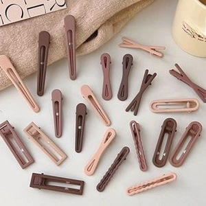 Close-up of matte resin hair clips in earth tones on aesthetic fabric background
