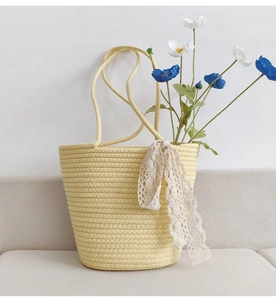 Detail of khaki woven cotton rope shoulder bag with lace ribbon and floral decoration
