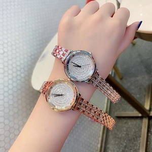 Detailed view of luxury silver and rose gold watches with full diamond-set dials for women