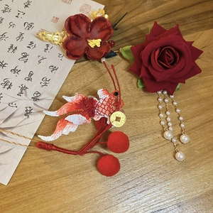 Close-up of Chinese New Year hair clips with red embroidery, pearls, and tassel details
