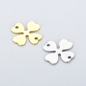 Macro detail of gold and silver four-leaf clover metal connectors with double-hole design
