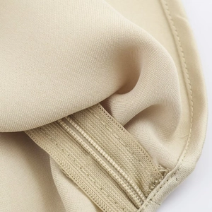 Dettaglio della fascia elastica e cuciture di precisione sul top allacciato beige