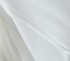 Vue macro des coutures de tissu en coton blanc de qualité et détails de texture