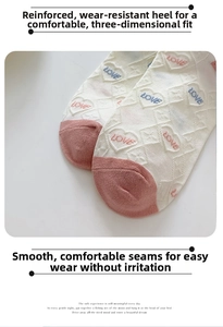 Close-up of cream cotton socks featuring pink heel, diamond patterns and love heart icons