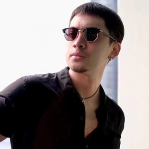 Classic black and gold half-frame polarized sunglasses worn by male model in soft light