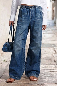 Outdoor street style shot of wide leg denim jeans with elastic waist in washed blue