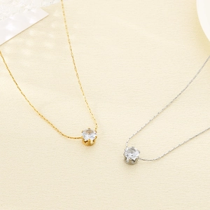 Détail de colliers dorés et argentés avec pendentifs en zircone cubique sertis à 6 griffes