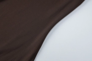 Dettaglio della trama in maglia marrone scuro con tessitura fine sull'abito a maniche lunghe