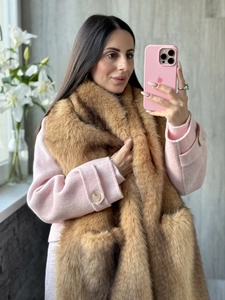 Detail of a pink wool coat featuring a large brown faux fox fur collar for winter