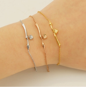 Trois bracelets minimalistes en or, argent et or rose avec pendentifs cœur sur modèle