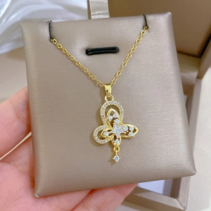 Macro detail of gold-plated double-layer butterfly pendant necklace with crystal zircons