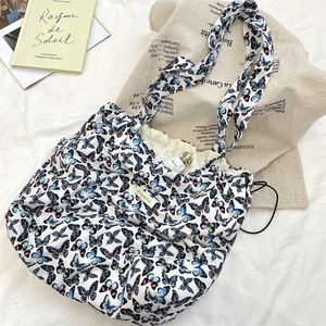 Detailed overhead view of butterfly print tote bag with drawstring on white fabric