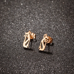 Boucles d'oreilles chat dorées au design minimaliste ajouré sur fond noir élégant