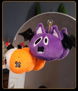 Detail of Halloween plush bats and pumpkins hanging in a clear acrylic display