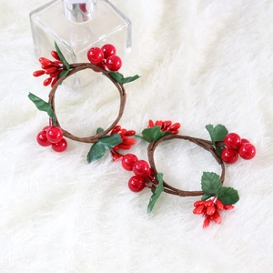 Detail of red berry Christmas napkin rings with green leaves and realistic brown twigs