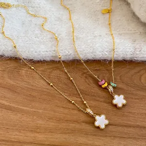 Elegant gold-plated flower necklaces with enamel beads on a soft knit background