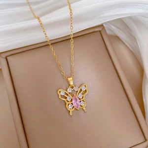 Detail of gold butterfly pendant with sparkling pink stone and clear zircons on silk