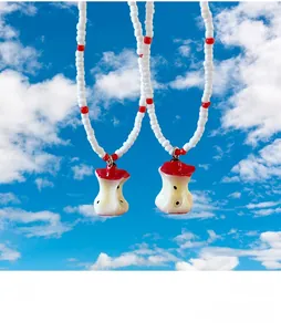 Detail view of crystal beaded necklace featuring a creative resin apple core pendant