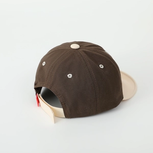 Détail d'une casquette en coton montrant la sangle réglable et les œillets brodés