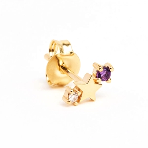 Detail of a gold star earring with a round purple gemstone and white zircon stones