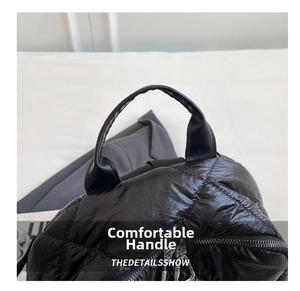 Makroaufnahme von gestepptem schwarzem Nylon-Rucksack mit Kunstledergriff und Doppelreißverschluss