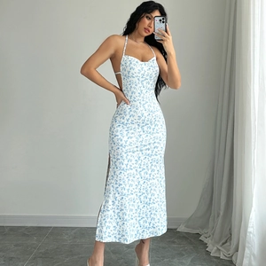 Detail view of white floral halter dress with open back and side slit on model