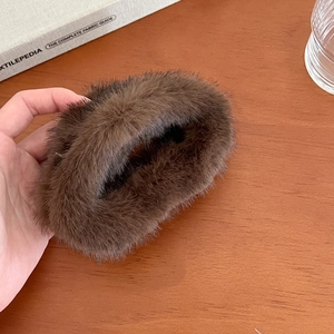 Gros plan sur la pince à cheveux en fausse fourrure de vison marron au style esthétique
