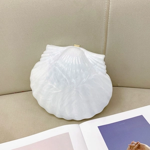 Détail du sac à main coquillage à texture marbre blanc avec fermoir doré chic