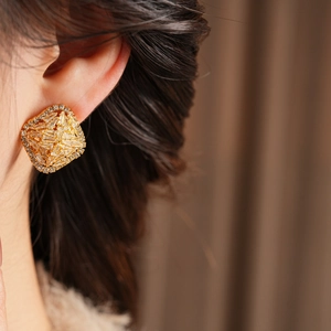Model wearing gold square earrings with zircon pave setting for a luxury look