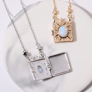 Macro detail of moon and star locket pendant with opal stone on marble tray