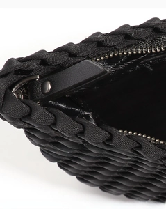 Macro shot of black woven tote bag detailing metal zipper and premium texture