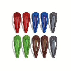 Detailed view of ten glittery teardrop hair clips in red, blue, green, brown, and grey