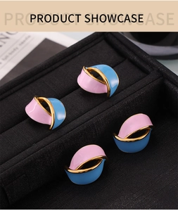 Macro detail of abstract pink and blue enamel wave earrings in a black velvet jewelry box