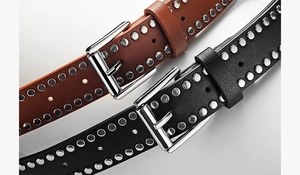 Detailed macro shot of punk style rivet belts in black and brown with silver buckles