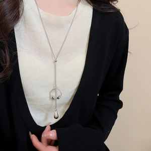 Detailed close-up of a silver long sweater chain necklace with water drop pendant on model